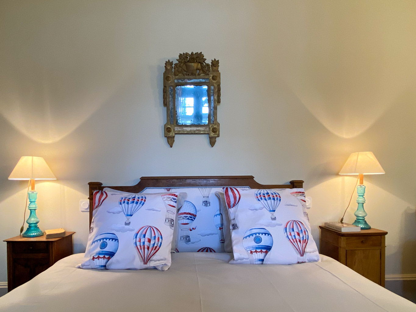 Château d&#039;Ainay-le-Vieil, the guest rooms, the Bigny Suite, view of the double bed with decorative cushions with hot-air balloon motifs and illuminated bedside tables