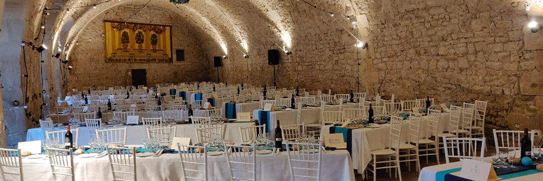 Château d'Ainay-le-Vieil, réception dans la salle des archers le soir avec effets d'éclairages et tables en épis